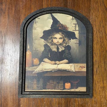 Witch behind desk at Academy w/ Candles in Small Arch Frame
